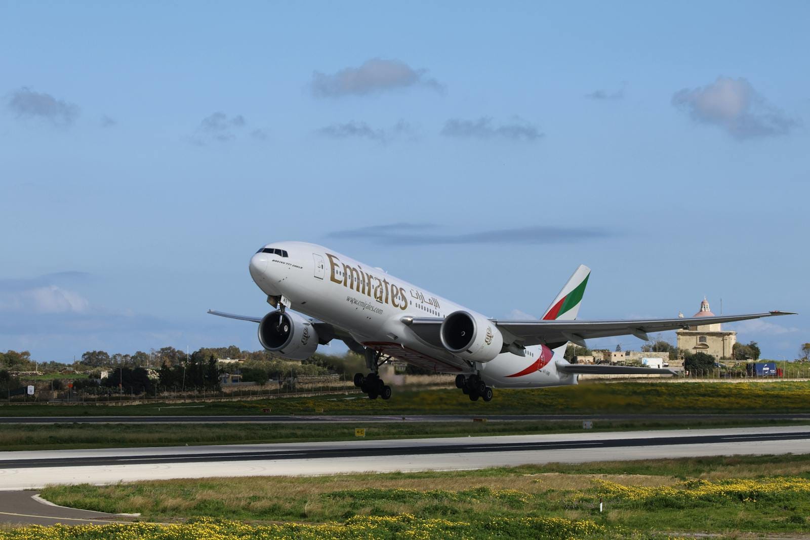 Emirates aircraft takes off against a clear blue sky, perfect for travel themes.